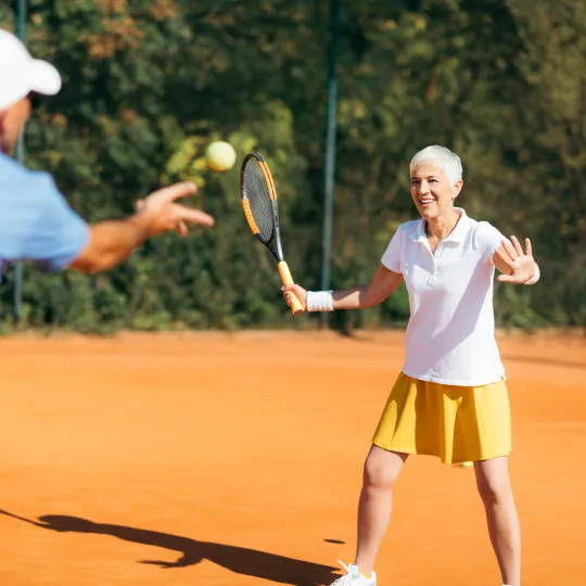 Older couple playing tennis